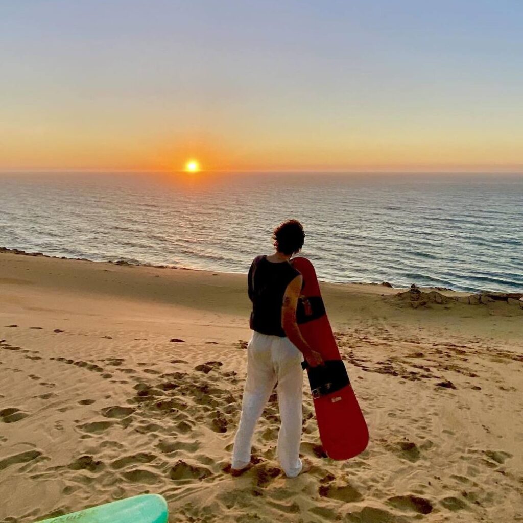 Sunset sandboarding Taghazout: amazing sunset over the golden dunes and the Atlantic ocean
