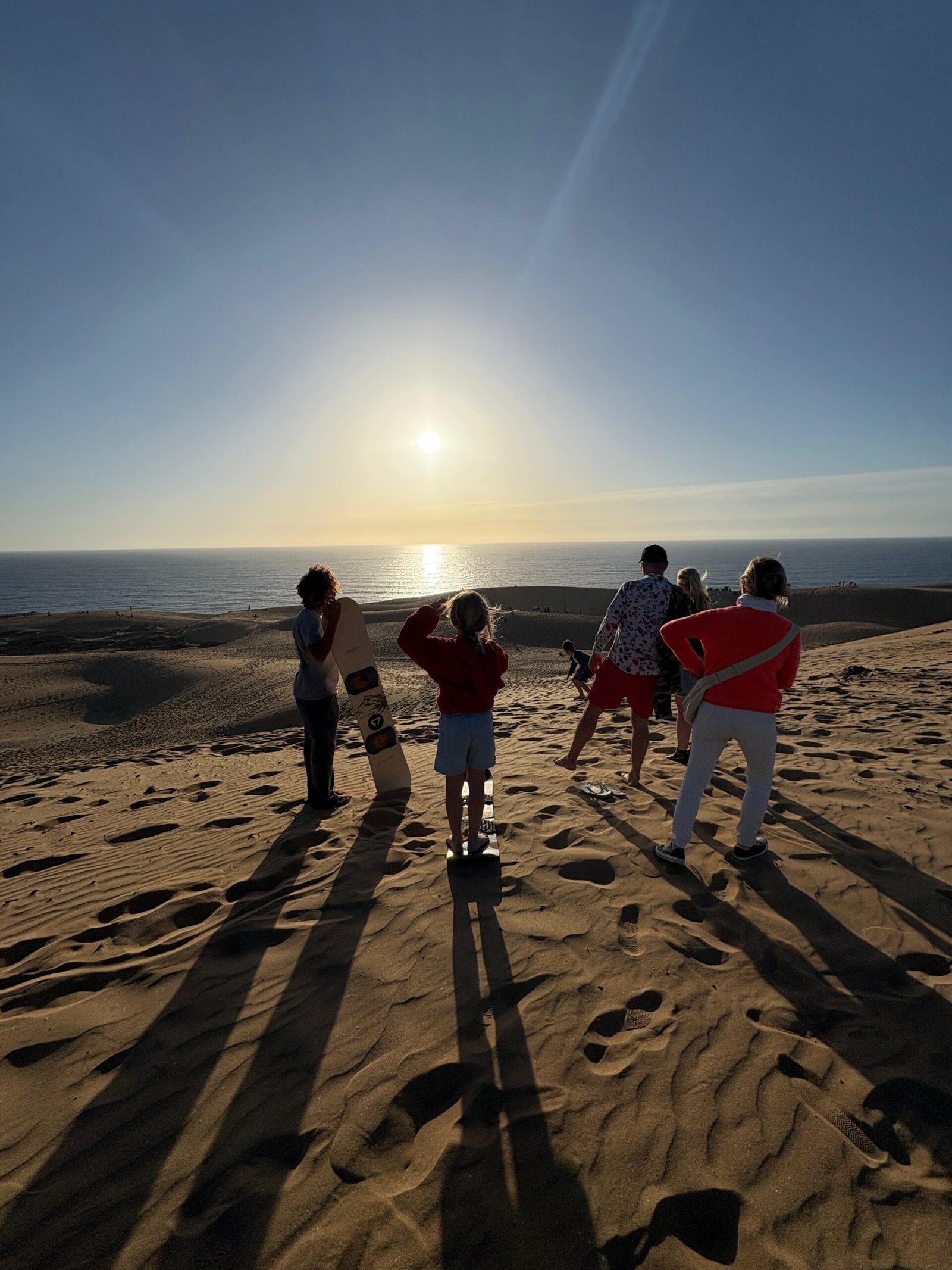 Group at sunset on the Timlalin Dunes during sandboarding near Taghazout, day 2