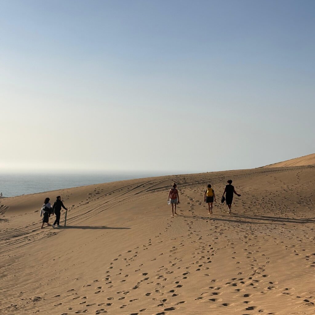 Travelers enjoying sandboarding in Taghazout