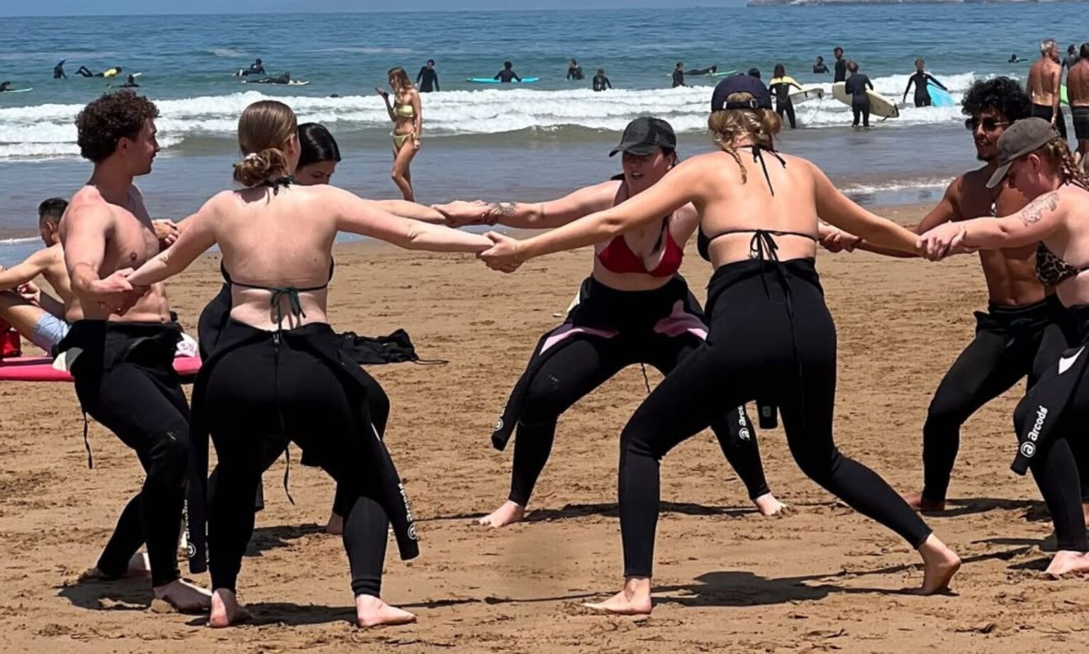 Surf instructor coaching beginner on beach in Taghazout before lesson