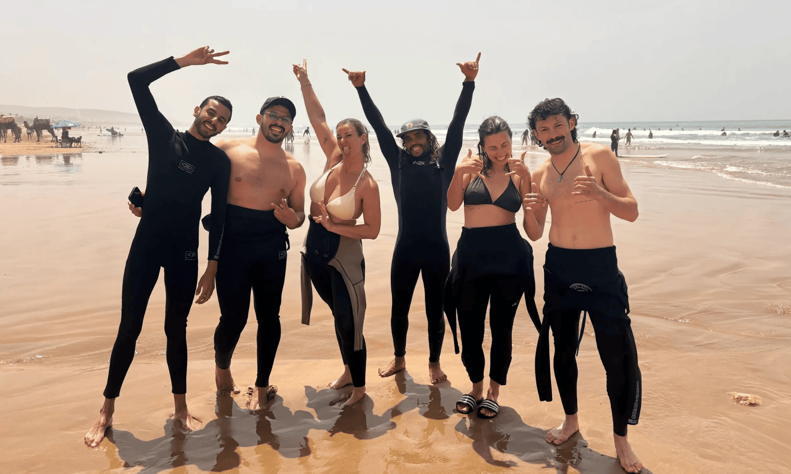 Surf lessons or Surf Camp Taghazout - Local surf instructor coaching small group beginner surf lesson on beach in Taghazout Morocco, no surf camp accommodation required